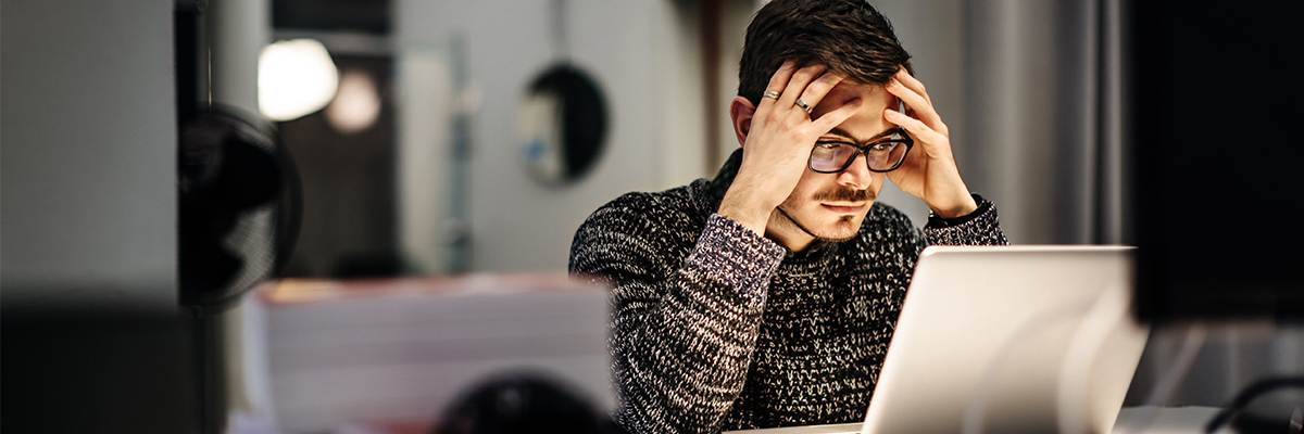 Stressed male working in front of a laptop BANNER