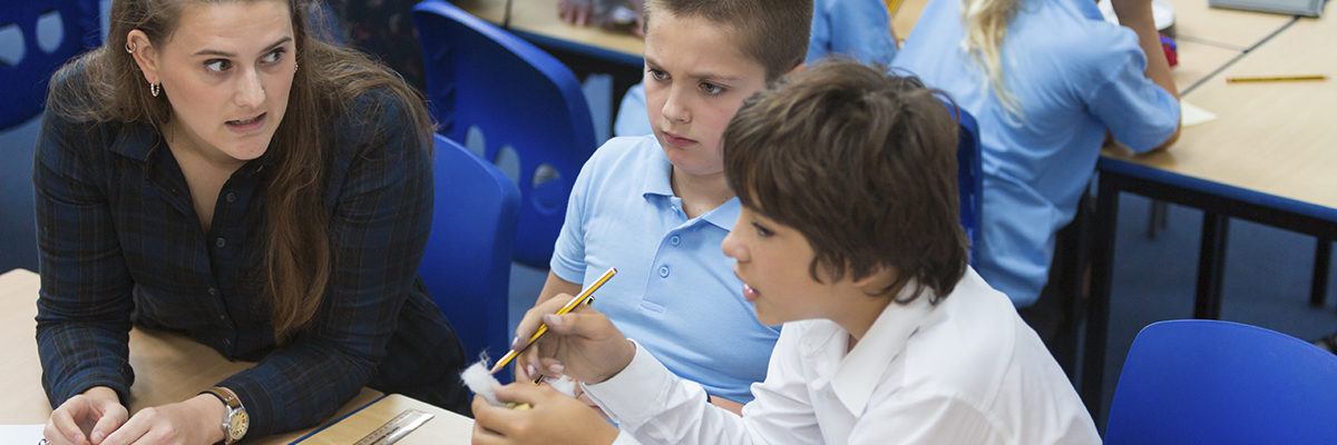 White female teacher with two male pupils