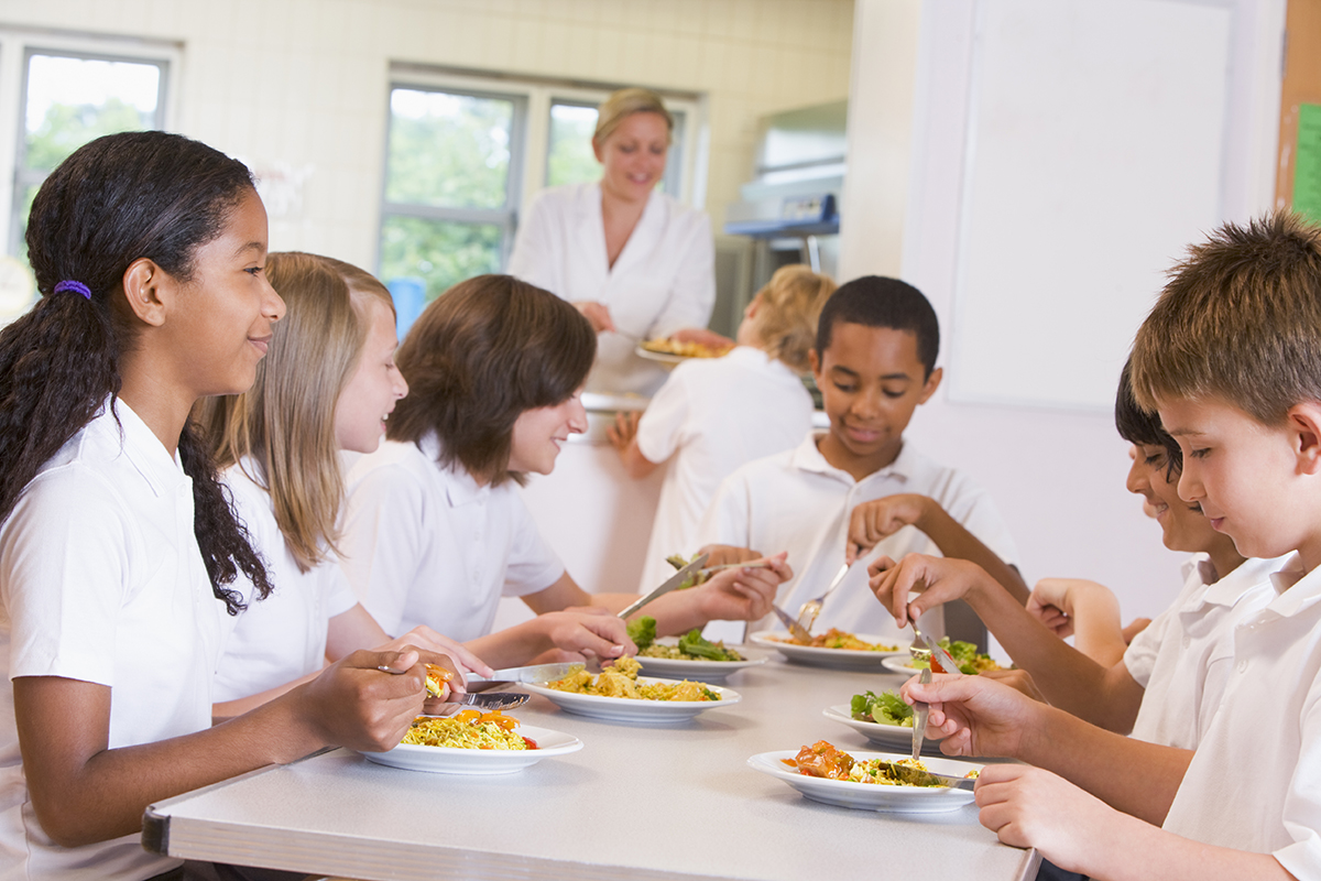 Mixed primary pupils eating school meal